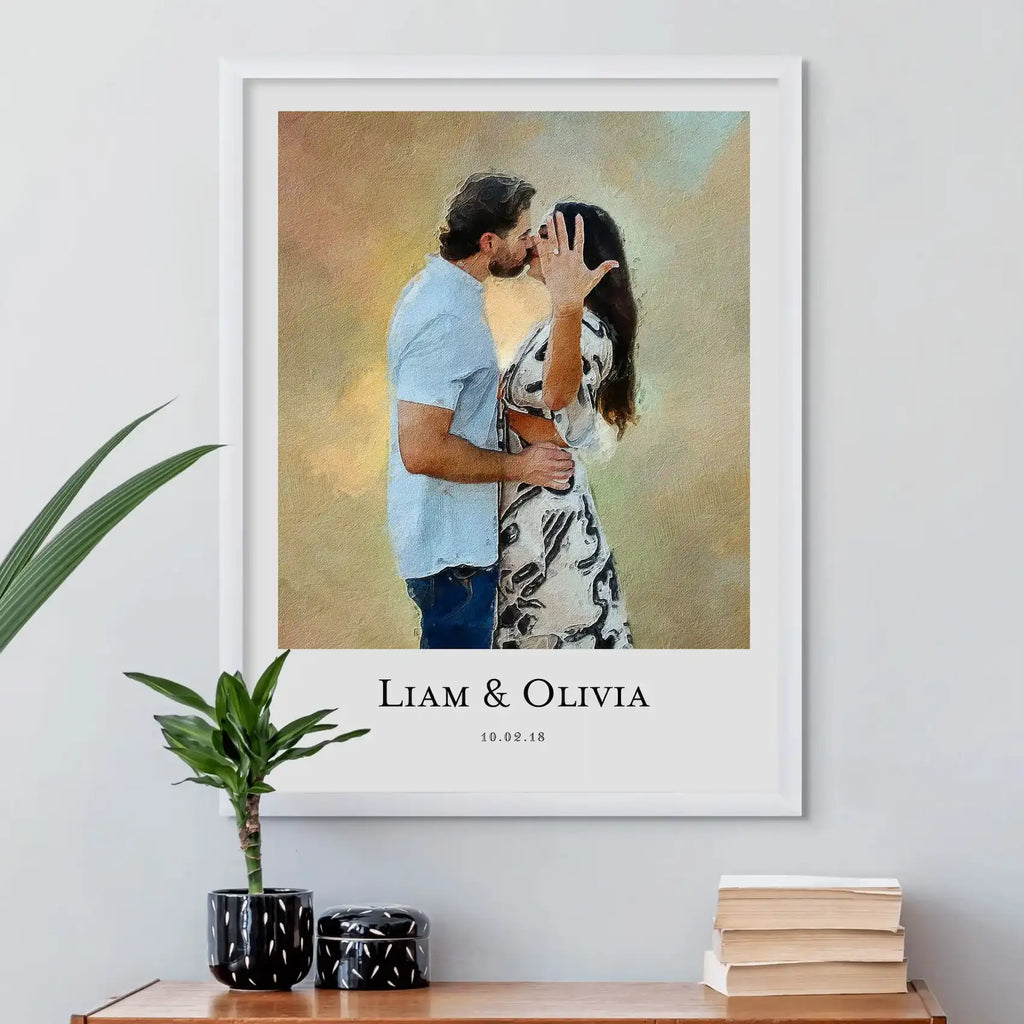 Oil-style portrait of a couple kissing, the woman showing a ring, in a white frame above a table with plants and books