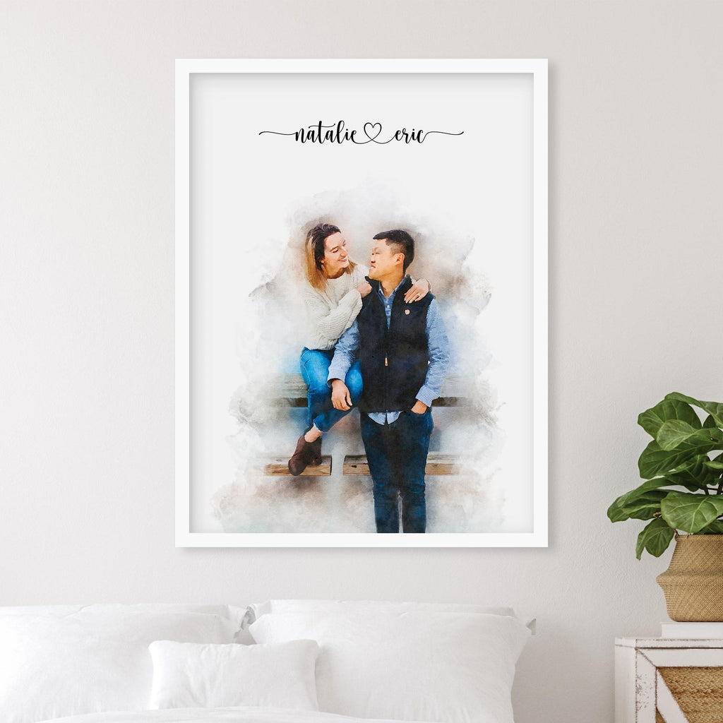 Watercolor-style portrait of a woman seated on a bench with a man standing beside her, in a white frame above a bed