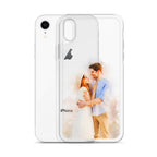 Clear iPhone XR case printed with a watercolor-style portrait of a couple embracing, beside a white iPhone